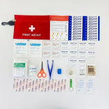 Trousse de premiers secours ouverte avec contenu étalé, montrant les fournitures médicales essentielles