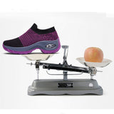Baskets de sport violettes pour femmes sur une balance, démontrant leur légèreté comparée à une pomme