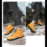 Bottes de randonnée jaunes pour hommes, marchant sur un sentier de montagne enneigé