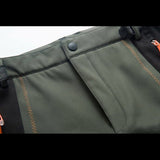 Bouton pression robuste sur la ceinture du pantalon de trekking imperméable pour femme, avec coutures renforcées.