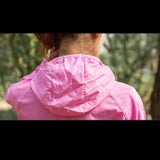 Capuche ajustable d’une veste imperméable rose, parfaite pour les activités en extérieur