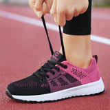 Chaussures de sport noires et roses pour femmes, serrage des lacets avant l'entraînement