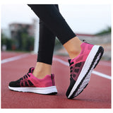 Chaussures de sport noires et roses pour femmes, semelle blanche, portées sur piste