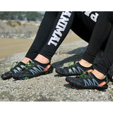 Chaussures aquatiques noires et vertes portées sur rochers, idéales pour le séchage rapide