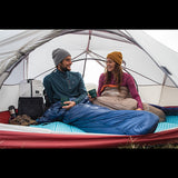 Couple dans une tente de camping ultralégère, profitant d'un moment convivial en plein air