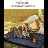 Couple assis sur un matelas de camping autogonflant devant une tente