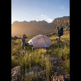Couple préparant la tente de camping ultralégère au lever du soleil, parfait pour les randonnées