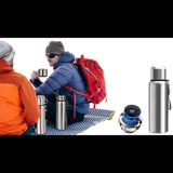 Deux randonneurs partageant une boisson chaude avec des bouteilles thermiques en acier inoxydable