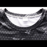 Détail de l'encolure d'un t-shirt de compression camouflage gris, couture visible