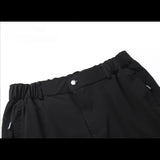 Détail de la ceinture et de la fermeture à bouton d'un pantalon noir d'été grande taille pour homme