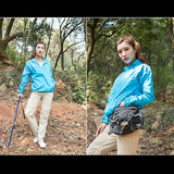 Femme en veste de randonnée bleue, tenant un bâton de marche, idéale pour les activités outdoor.