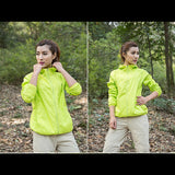 Femme en veste de randonnée jaune, explorant un sentier forestier, protection solaire intégrée