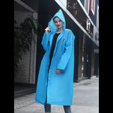 Femme portant un manteau de pluie bleu en ville