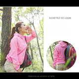 Femme portant une veste de randonnée rose, sac à dos inclus, adaptée aux randonnées en forêt