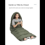 Femme utilisant un sac de couchage vert avec capuche, gardant la tête au chaud