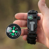 Gros plan sur la boussole et les outils du bracelet de survie en paracorde