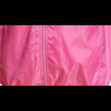 Gros plan sur la texture imperméable et le zip central de la veste de randonnée rose