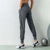 Pantalon de sport gris pour femme, vue arrière montrant les détails du design et les poches