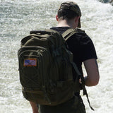 Homme avec un sac à dos étanche près de l'eau, parfait pour les activités aquatiques et terrestres