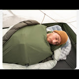 Homme dormant confortablement dans une doublure de sac de couchage ultralégère verte en camping