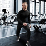 Homme portant un t-shirt de compression noir dans une salle de sport, entraînement, fitness