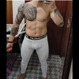 Homme prenant un selfie en portant des leggings de compression blancs, tatouage sur l'épaule visible