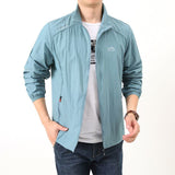 Homme portant une veste de randonnée imperméable bleu clair, confortable et légère