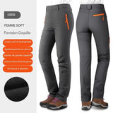 Pantalon de randonnée gris pour femme, tissu hydrophobe et coupe-vent, coutures renforcées, poches spacieuses et intérieur polaire.