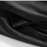 Poche de la veste imperméable noire, montrant la capacité de rangement pour un smartphone