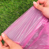 Poncho imperméable rose déplié montrant sa flexibilité et sa résistance