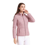 Femme portant une veste matelassée rose avec capuche, posant de manière décontractée