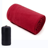 Sac de couchage polaire rouge enroulé, ultraléger et facile à transporter