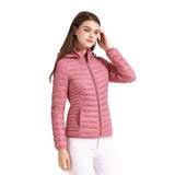 Femme portant une veste matelassée rose avec capuche, posant avec la main sur la tête