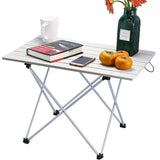 Table de camping utilisée comme table de lecture avec livre, téléphone et tasse, vue d'intérieur