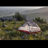 Tente de camping ultralégère installée sur une colline, parfaite pour admirer la vue