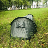 Tente de camping noire installée sur une pelouse, parfaite pour le camping en solo